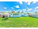 The home's backyard shows the expansive grass, exterior of house, and outdoor patio furniture at 10436 117Th Dr, Largo, FL 33773