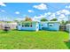 The large backyard features an exterior view of the home, well-maintained grass, and ample space for outdoor activities at 10436 117Th Dr, Largo, FL 33773