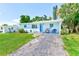 Cozy single-story home with a blue exterior, well-manicured lawn, and a charming carport at 10436 117Th Dr, Largo, FL 33773