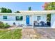Charming, single-story home with blue exterior, covered entry, and walkway leading to the front door at 10436 117Th Dr, Largo, FL 33773