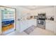 Bright kitchen with stainless appliances, white cabinetry, and an open view into the adjacent bedroom at 10436 117Th Dr, Largo, FL 33773