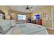 Bright bedroom featuring two beds, a ceiling fan, and a window offering natural light at 100 Bayside Dr # 202, Clearwater Beach, FL 33767