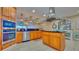 Well-equipped kitchen featuring wood cabinets, updated appliances, and stylish lighting at 100 Bayside Dr # 202, Clearwater Beach, FL 33767