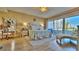 Bright main bedroom with balcony access, desk, chaise lounge, and chandelier at 100 Bayside Dr # 202, Clearwater Beach, FL 33767
