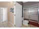This bathroom offers a shower/tub combo, tile floors and walls, and a neutral color scheme at 10032 Basin St, New Port Richey, FL 34655