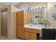 Bright bathroom features wood cabinets, white countertop, framed mirror and shower with glass door at 10032 Basin St, New Port Richey, FL 34655