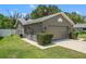 View of the side of the home, showing garage, driveway, and landscaping at 10032 Basin St, New Port Richey, FL 34655