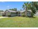 A beautifully landscaped home with a well-maintained lawn and a palm tree at 10032 Basin St, New Port Richey, FL 34655