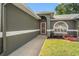 A close-up of the front entrance of the home featuring gray exterior and beautiful plants at 10032 Basin St, New Port Richey, FL 34655