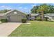 Charming single Gathering home showcasing a well-manicured lawn and gray exterior paint at 10032 Basin St, New Port Richey, FL 34655