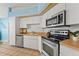 This kitchen features stainless steel appliances, light wood counters and white cabinets and is brightly lit at 10032 Basin St, New Port Richey, FL 34655