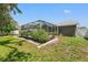 View of the screened-in pool area with manicured landscaping in the backyard at 10032 Basin St, New Port Richey, FL 34655