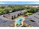 Inviting aerial view of a pool and condos surrounded by green lawns, gardens, and community features at 10195 Sailwinds N Blvd # 208, Largo, FL 33773