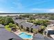Scenic aerial shot featuring condo buildings, manicured landscapes, a community pool, and picturesque lake views at 10195 Sailwinds N Blvd # 208, Largo, FL 33773