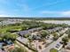 Community aerial view revealing residential buildings, extensive green spaces, a pool, and scenic lake views at 10195 Sailwinds N Blvd # 208, Largo, FL 33773