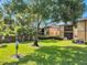Green grass backyard with a tree and pet area at 10195 Sailwinds N Blvd # 208, Largo, FL 33773