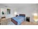 Clean bedroom with a bed, two side tables, and a hall leading to a bathroom at 10195 Sailwinds N Blvd # 208, Largo, FL 33773