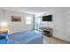 Bright bedroom with sliding glass doors, a mounted TV, and modern furnishings at 10195 Sailwinds N Blvd # 208, Largo, FL 33773