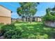 Condo exterior with a large shade tree and a spacious green lawn, creating a serene and inviting atmosphere at 10195 Sailwinds N Blvd # 208, Largo, FL 33773