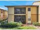 Two-story home exterior features private screened patios, lush landscaping, and neutral paint at 10195 Sailwinds N Blvd # 208, Largo, FL 33773