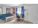 Bright living room showcasing wood-look tile flooring, comfortable seating, and a desk near a window at 10195 Sailwinds N Blvd # 208, Largo, FL 33773