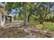 Expansive backyard with mature trees and partial view of the pool and back porch at 10265 130Th St, Largo, FL 33774