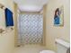 Bathroom featuring a shower with patterned curtain and neutral color palette at 10265 130Th St, Largo, FL 33774