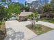 Long concrete driveway with a two-car garage and trees at 10265 130Th St, Largo, FL 33774
