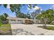 Well-maintained one-story home with a two-car garage, and charming landscaping in the daylight at 10265 130Th St, Largo, FL 33774