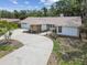Charming single-story home featuring a spacious driveway, attached garage, and mature landscaping at 10265 130Th St, Largo, FL 33774