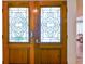 Elegant wooden double doors with decorative glass, providing a glimpse into the home's interior at 10265 130Th St, Largo, FL 33774