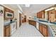 Spacious kitchen featuring white appliances, wooden cabinets, and blue tiled countertops, offering a blend of functionality and style at 10265 130Th St, Largo, FL 33774