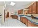 Open kitchen design with wooden cabinets, blue tiled countertops, and ample natural light from a skylight above at 10265 130Th St, Largo, FL 33774