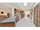 Well-lit kitchen featuring a curved island with blue tiled countertops, wooden cabinets, and white tile flooring at 10265 130Th St, Largo, FL 33774