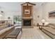 Spacious living room with a brick fireplace, ceiling fan, and view of the pool area at 10265 130Th St, Largo, FL 33774