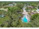 Aerial view of a private backyard oasis with a sparkling pool, lush trees, and a cozy seating area at 10265 130Th St, Largo, FL 33774