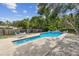 Backyard pool with clear blue water surrounded by patio and lush greenery at 10265 130Th St, Largo, FL 33774