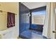 Unique walk-in shower showcasing contemporary blue tile work, stylish fixtures, and a window at 10265 130Th St, Largo, FL 33774