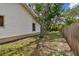 Side yard with grass, trees and wooden fence that lines the property at 10265 130Th St, Largo, FL 33774