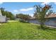 Spacious backyard featuring lush green grass and beautiful flowering trees at 11001 Ridgedale Rd, Temple Terrace, FL 33617