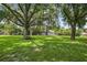 Expansive backyard featuring mature trees, lush green grass, and detached garage at 11001 Ridgedale Rd, Temple Terrace, FL 33617