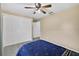 Bedroom with tile floors, ceiling fan, closet with louvered doors, and a bed with a blue quilt at 11001 Ridgedale Rd, Temple Terrace, FL 33617