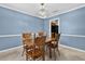 Charming dining area featuring a wooden table set, blue walls, and a stylish light fixture at 11001 Ridgedale Rd, Temple Terrace, FL 33617