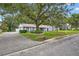 Inviting single-story home featuring brick facade, mature shade trees, and well-manicured landscaping at 11001 Ridgedale Rd, Temple Terrace, FL 33617