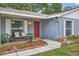 Charming home featuring a red door, brick facade, and lush landscaping at 11001 Ridgedale Rd, Temple Terrace, FL 33617