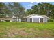 Charming single-story home with gray brick exterior, lush lawn, and mature landscaping at 11001 Ridgedale Rd, Temple Terrace, FL 33617