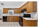 Traditional kitchen with wooden cabinets, black appliances, and tile flooring at 11001 Ridgedale Rd, Temple Terrace, FL 33617