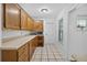 Functional kitchen features wood cabinets, white countertop, and black-and-white tile flooring at 11001 Ridgedale Rd, Temple Terrace, FL 33617