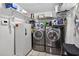 Laundry area equipped with stainless steel washer and dryer, shelving, and white storage unit at 11001 Ridgedale Rd, Temple Terrace, FL 33617