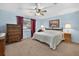 Comfortable bedroom featuring light blue walls, soft carpeting, and traditional furnishings at 11001 Ridgedale Rd, Temple Terrace, FL 33617